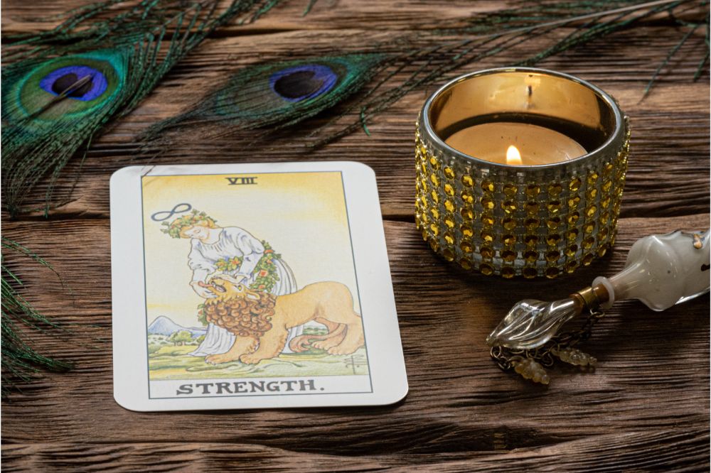 Strength tarot card on fortune teller wooden table background.