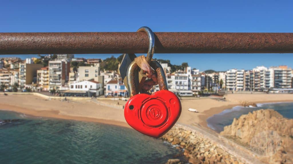 a red lock hanging from a bridge
