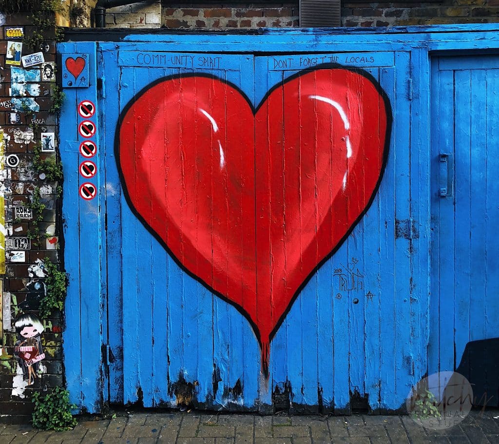 un gran corazón rojo pintado en la puerta de un granero azul