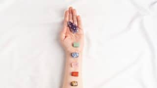 Healing reiki chakra crystals on woman's hands. Gemstones for wellbeing, meditation, relaxation